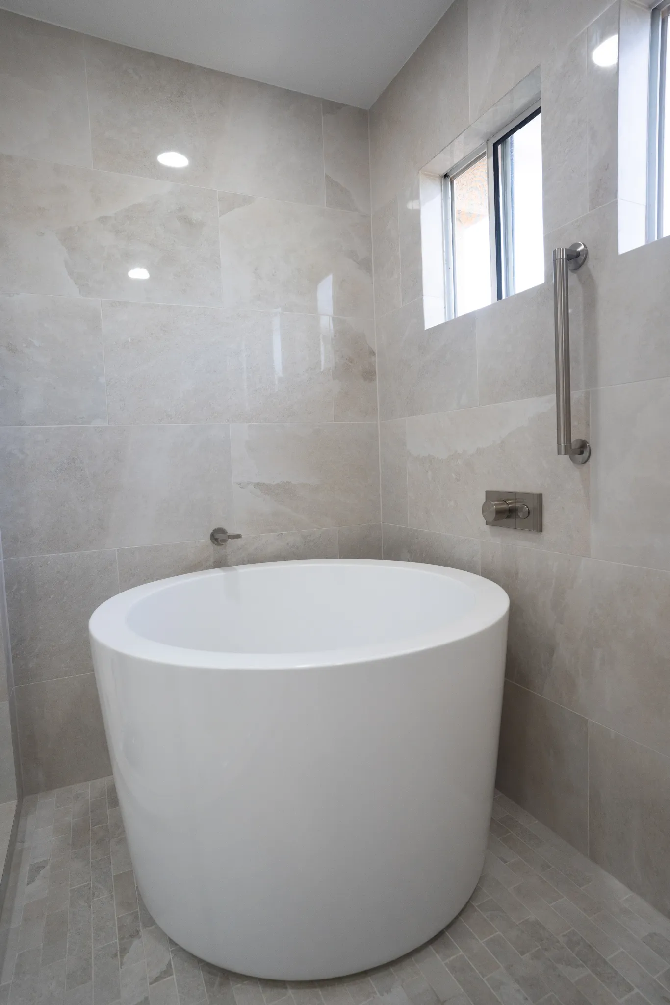 Pacific Cove round soaking tub in stone tile
