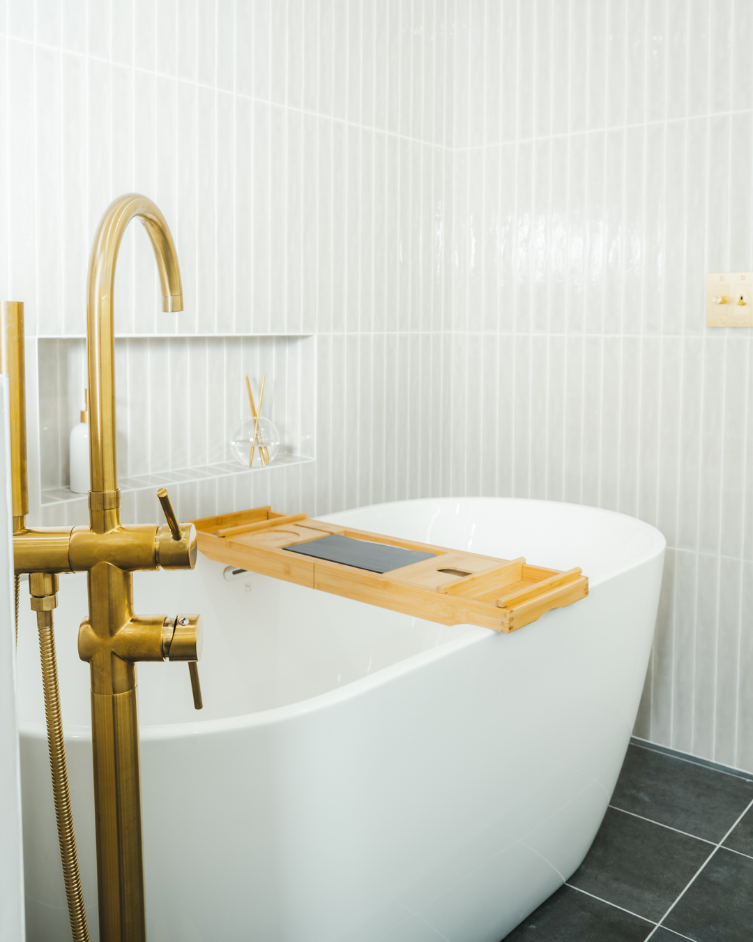 Randall Avenue spa bathroom — freestanding tub with brass floor-mount faucet